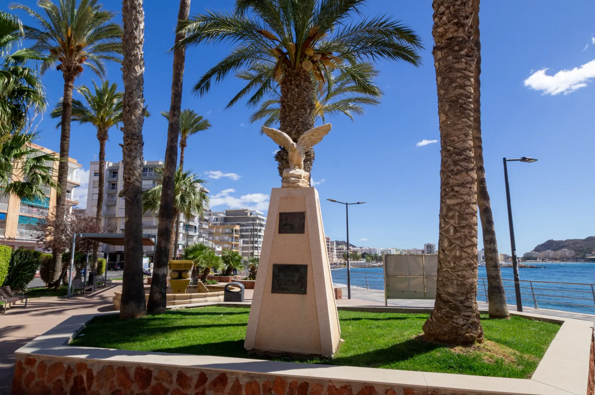 Seafront monument among palm trees in Águilas