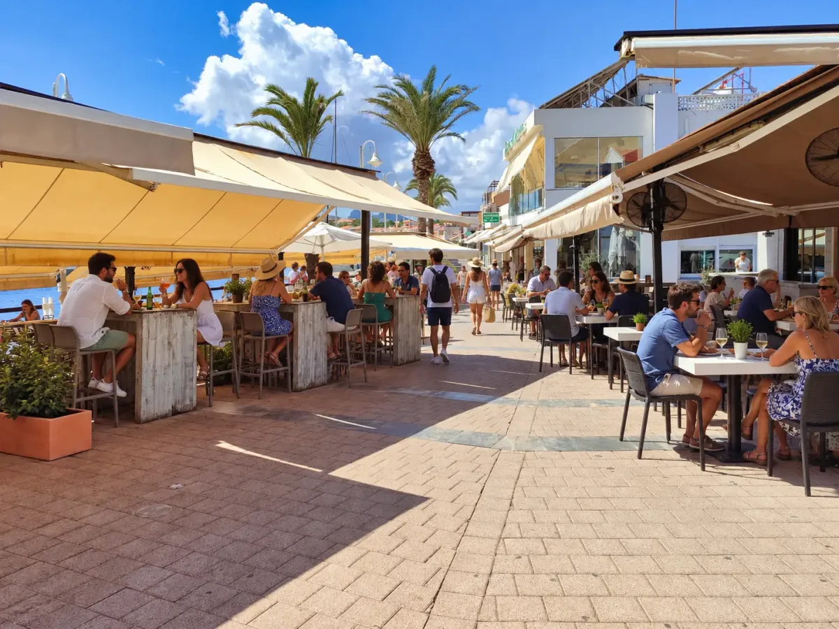 Personnes mangeant sur les terrasses ombragées des restaurants à côté du port de Cabo de Palos