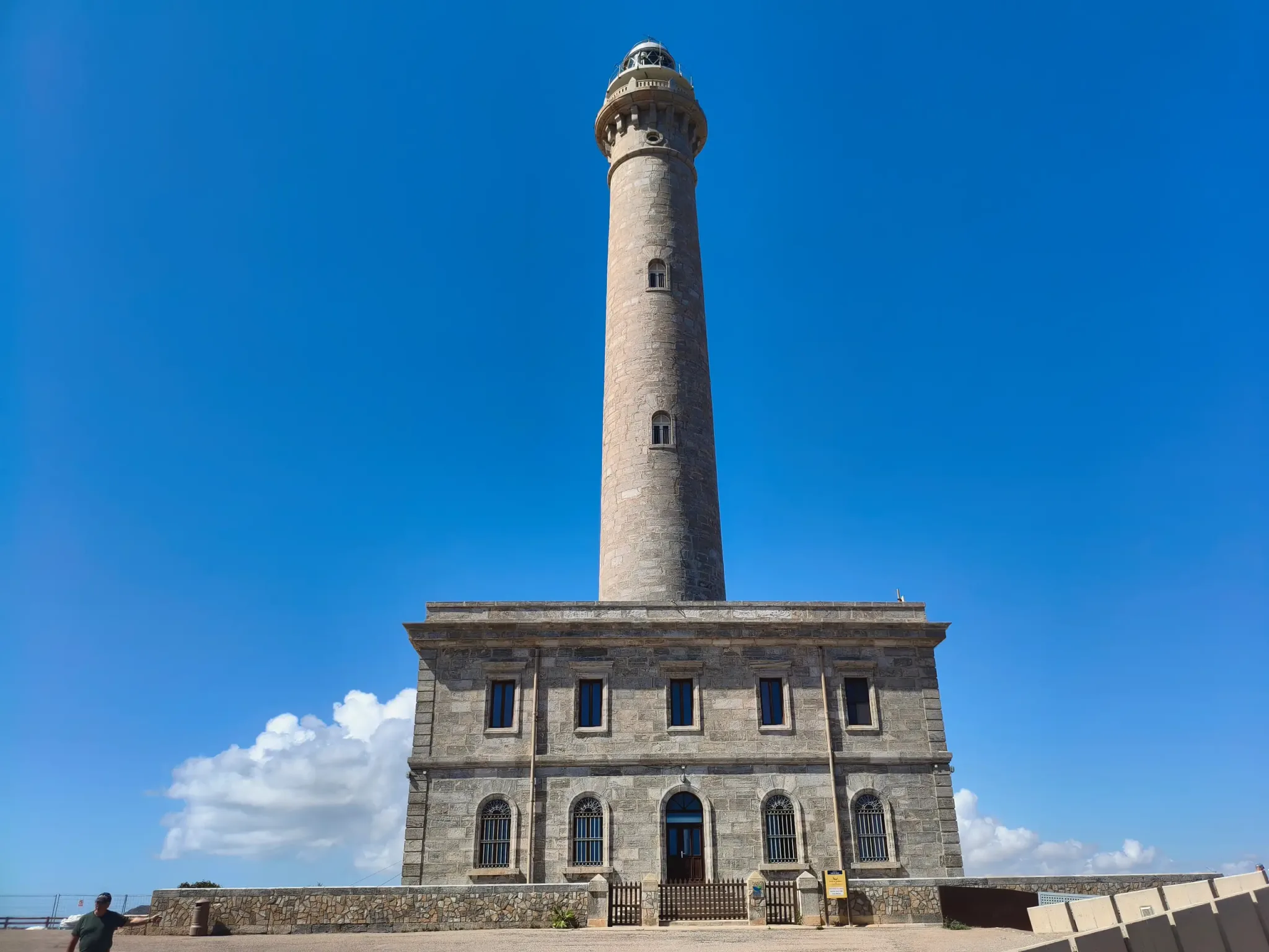 Front view of Cabo de Palos Lighthouse beneath a clear blue sky