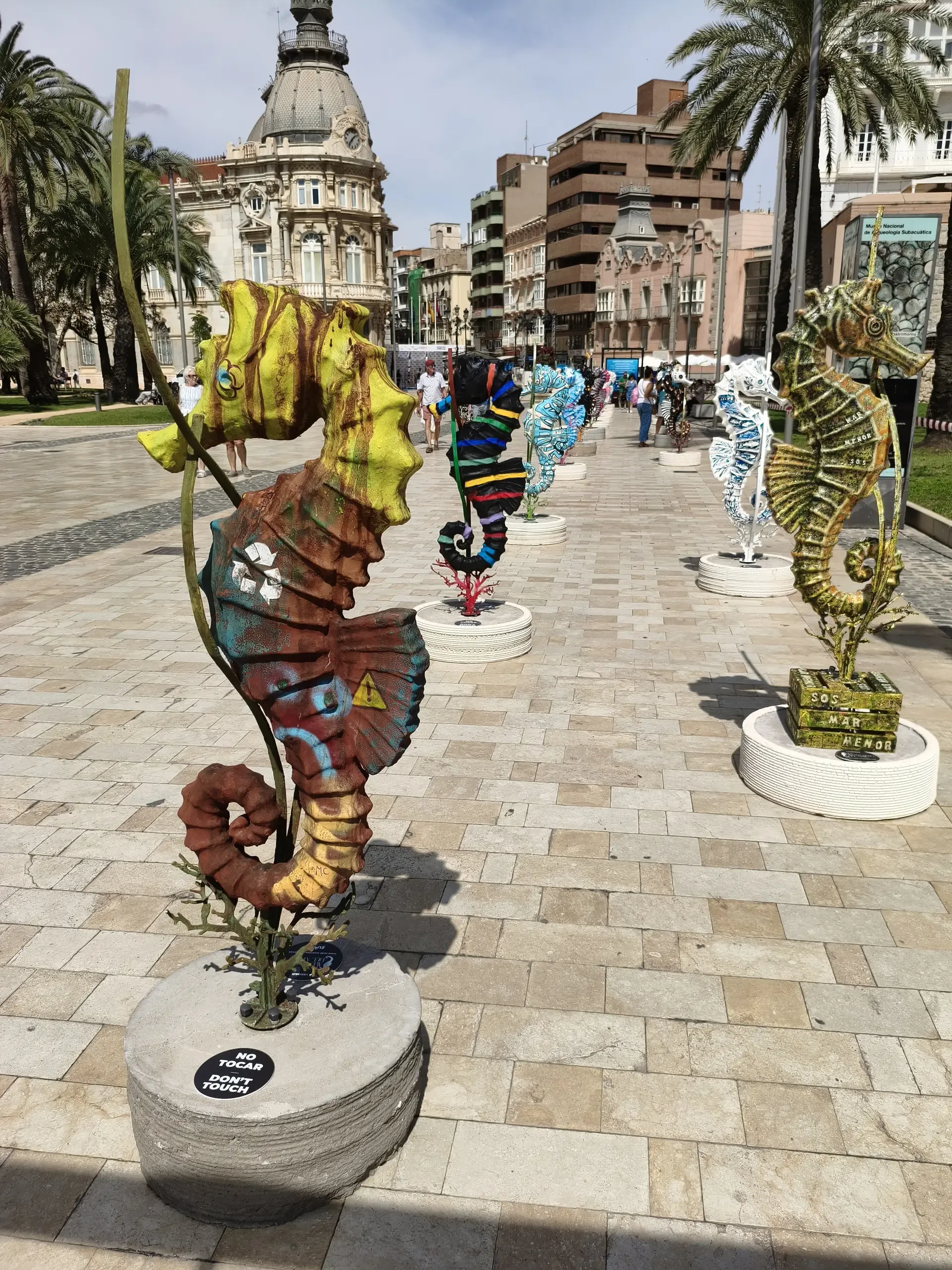 Sculptures contemporaines colorées bordant une rue piétonne de Carthagène