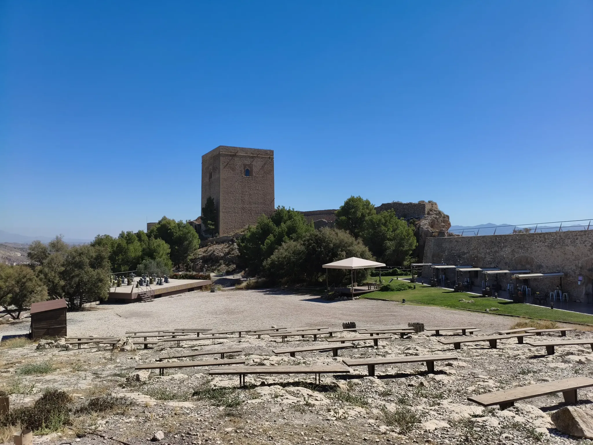 Vestiges archéologiques avec une tour médiévale derrière eux au château de Lorca