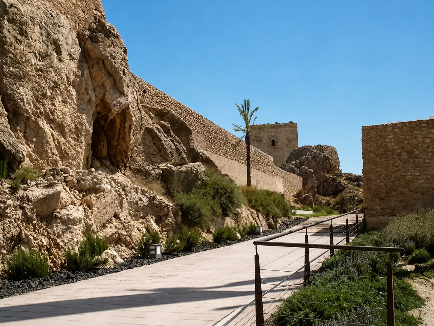 Path between rocky outcrops and stone walls inside Lorca Castle