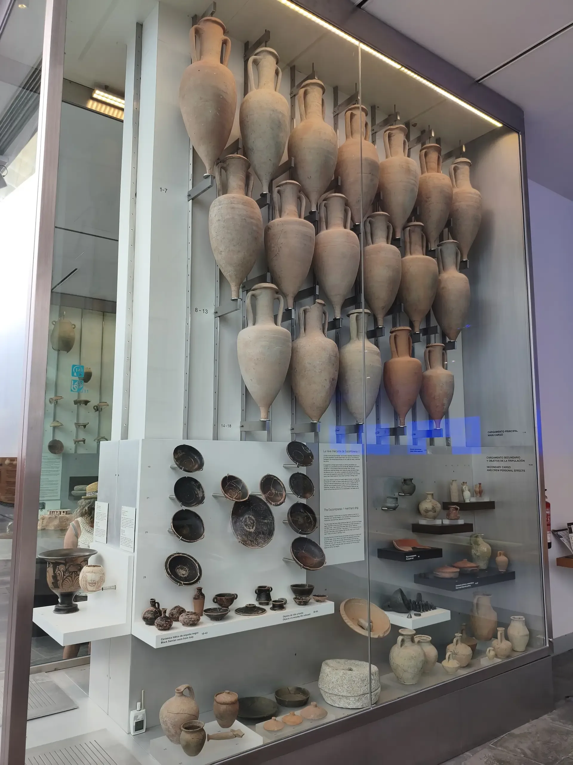 Amphorae and smaller archaeological objects displayed in a museum case