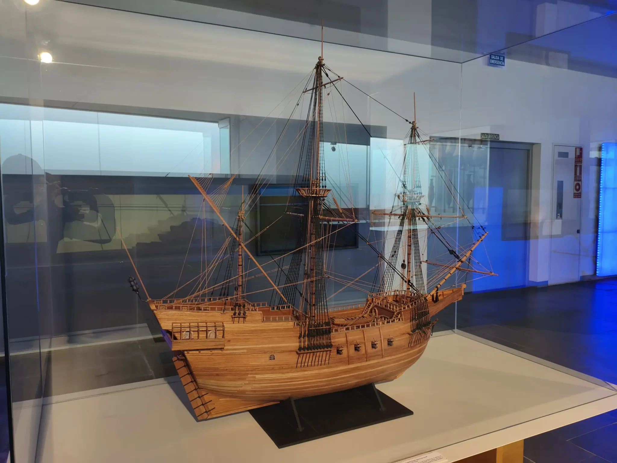 Detailed wooden sailing ship model in a glass case