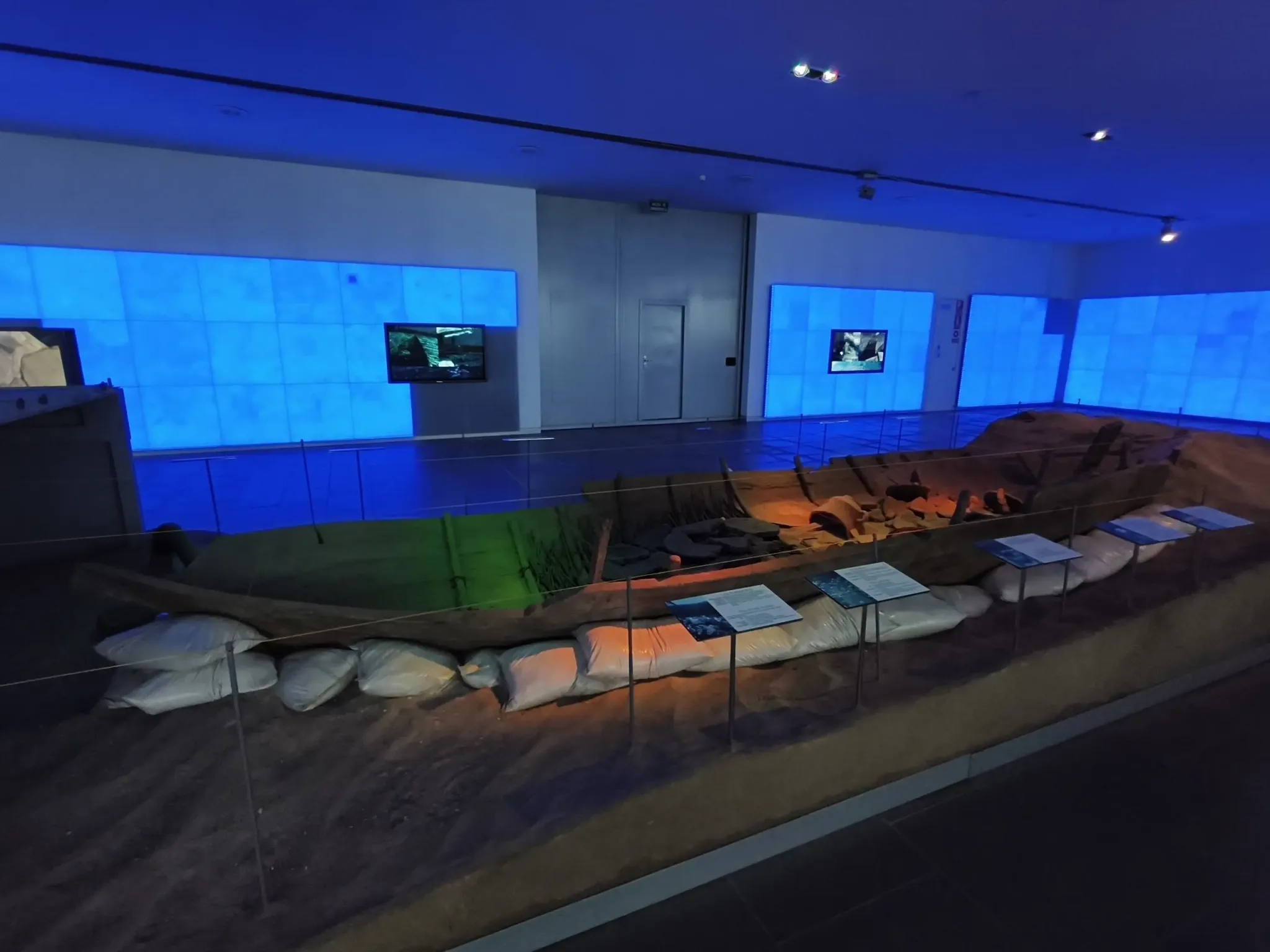 Surviving wooden elements from an ancient vessel in a blue-lit display