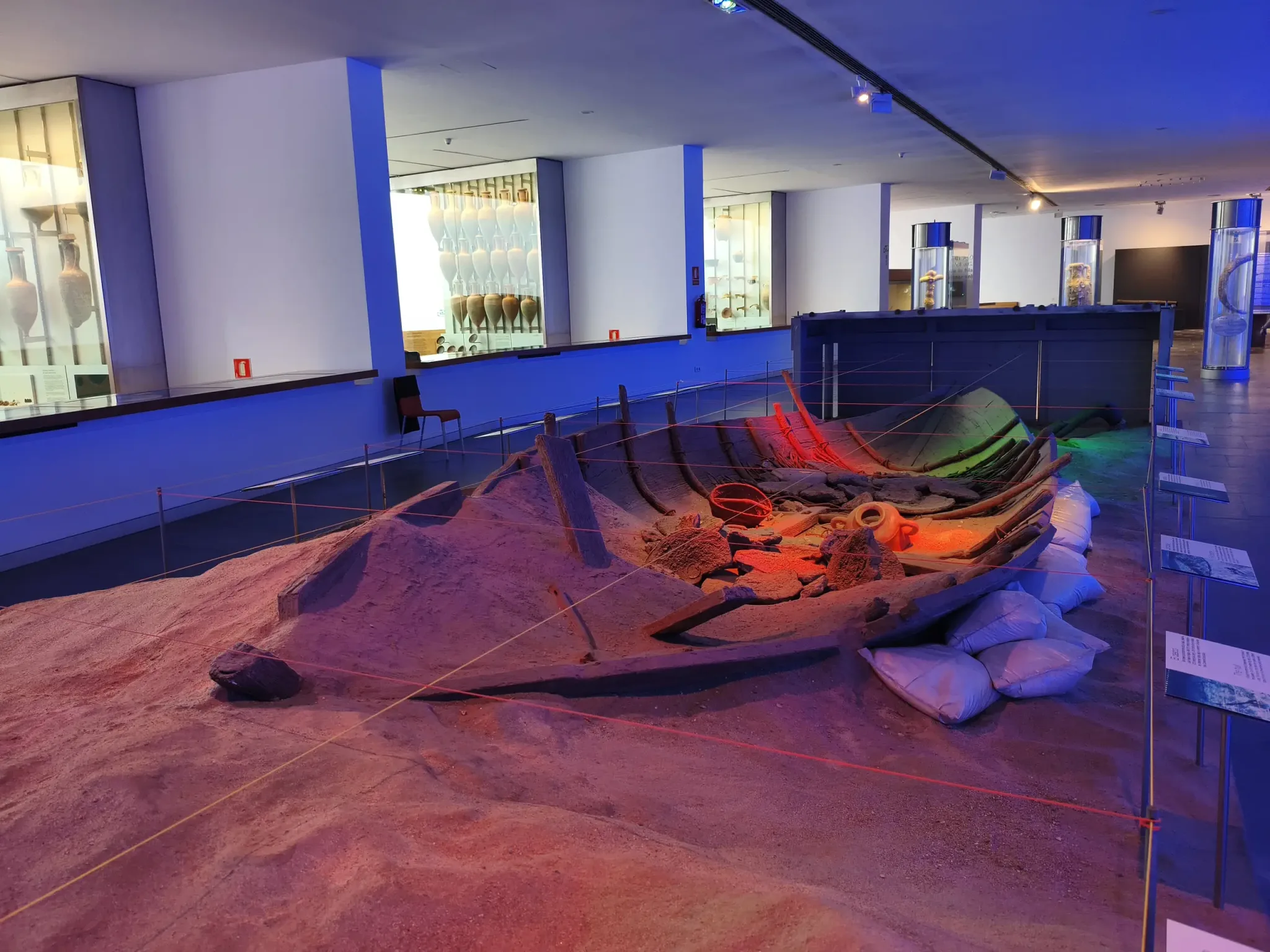 Ancient ship remains arranged in an illuminated gallery at ARQVA