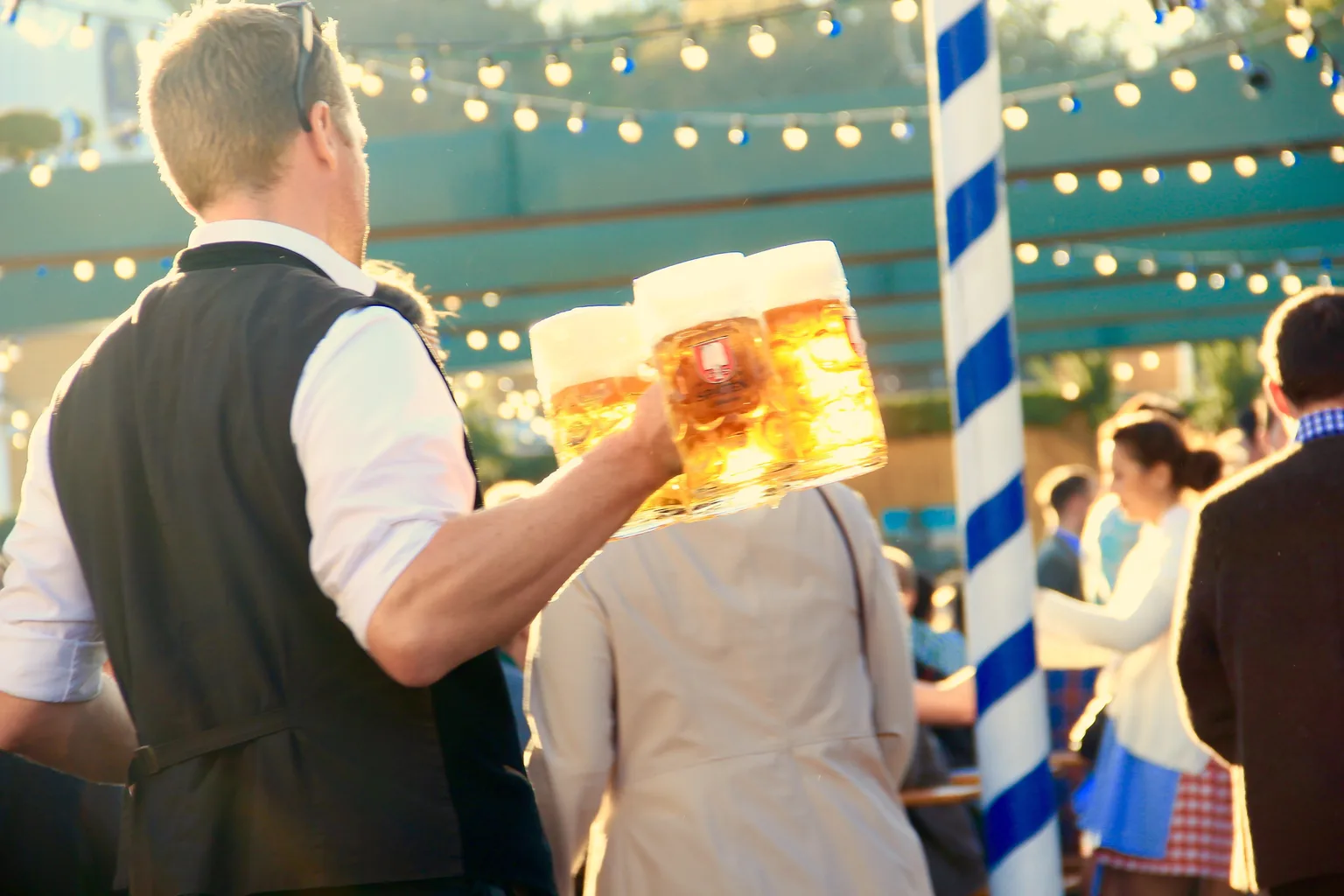 Un camarero lleva jarras de cerveza entre el público de un Oktoberfest en Múnich