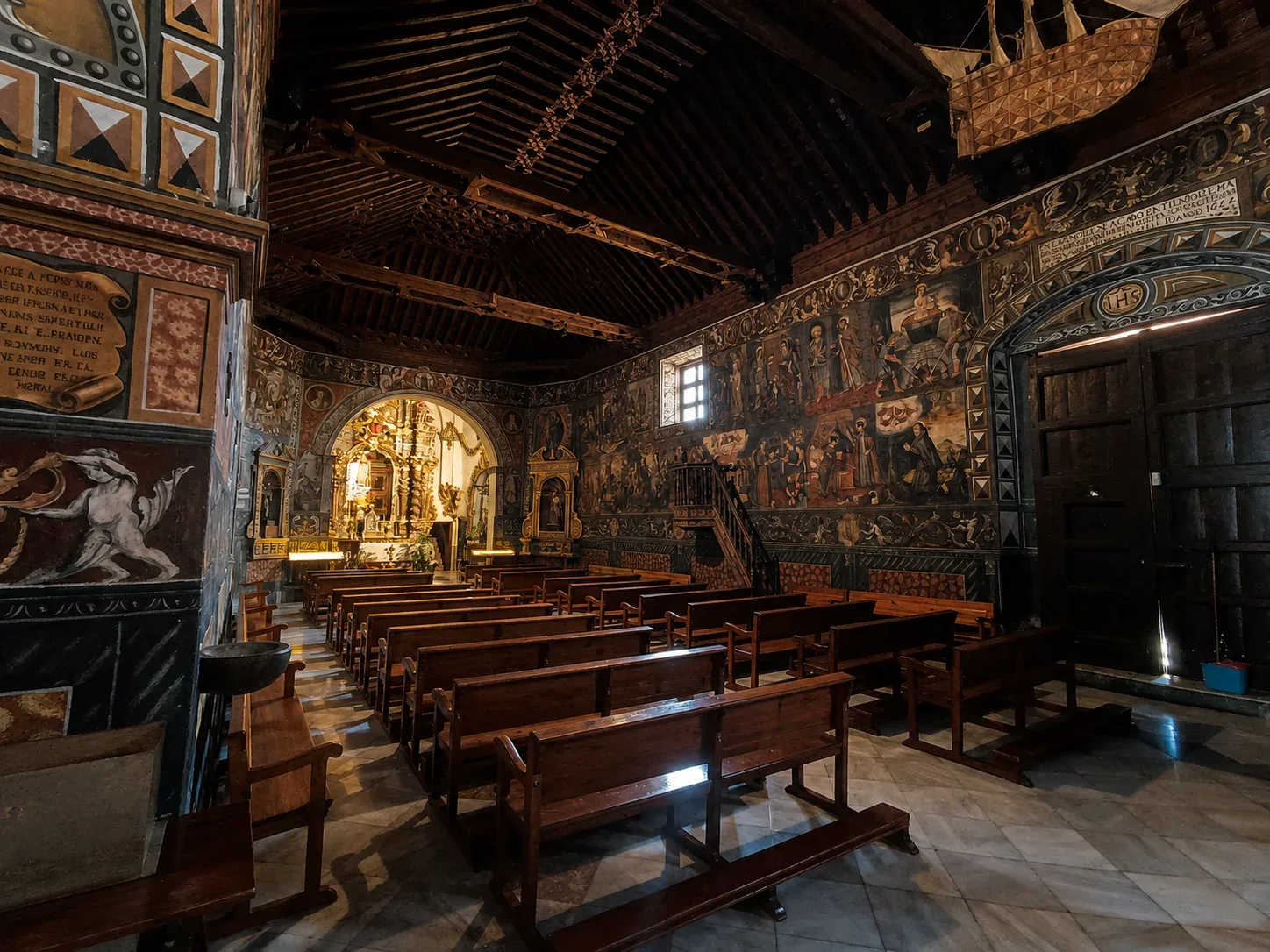 Carved Mudéjar wooden ceiling above the painted entrance wall of Santa Eulalia Sanctuary
