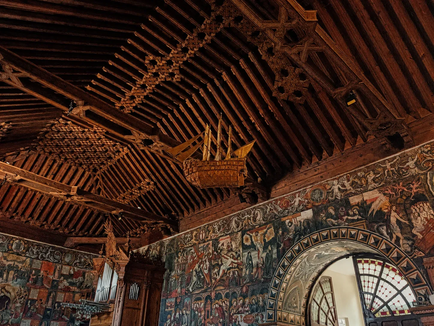 Detail of the carved wooden ceiling, painted wall and arched doorway