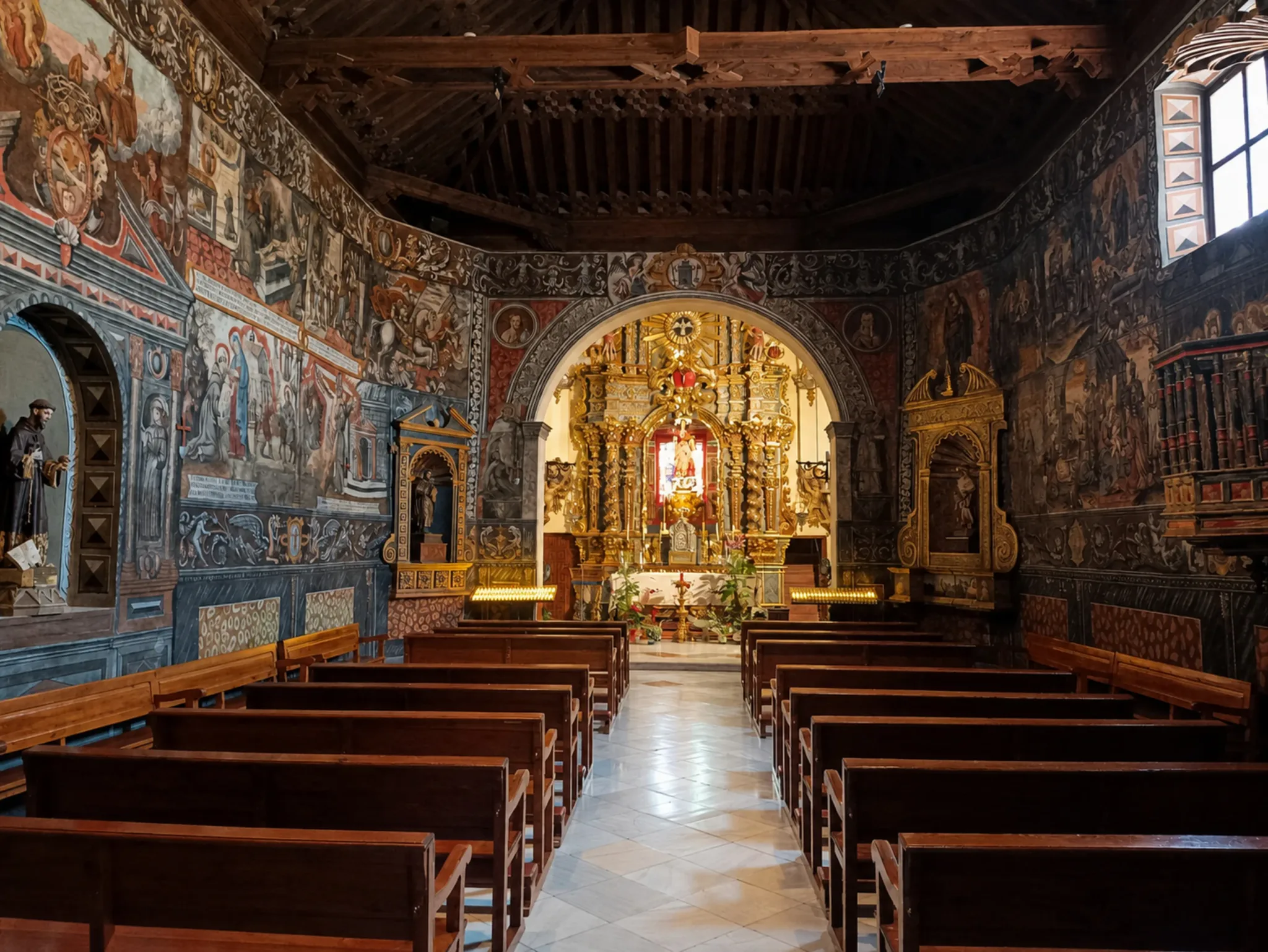 Painted nave and wooden pews facing the gilded altar inside Santa Eulalia Sanctuary