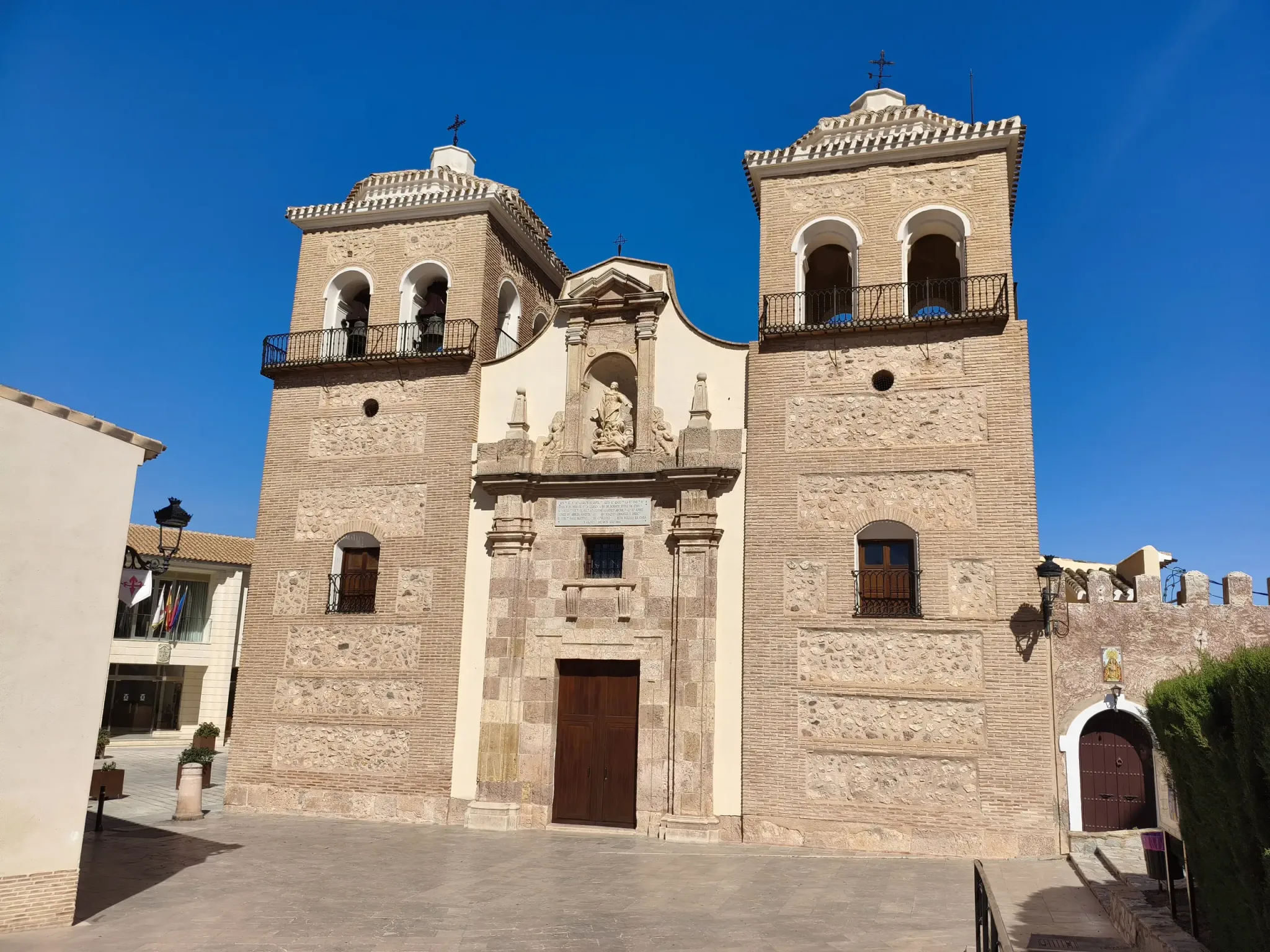Fachada de piedra con dos torres de la iglesia de Santa María la Real de Aledo