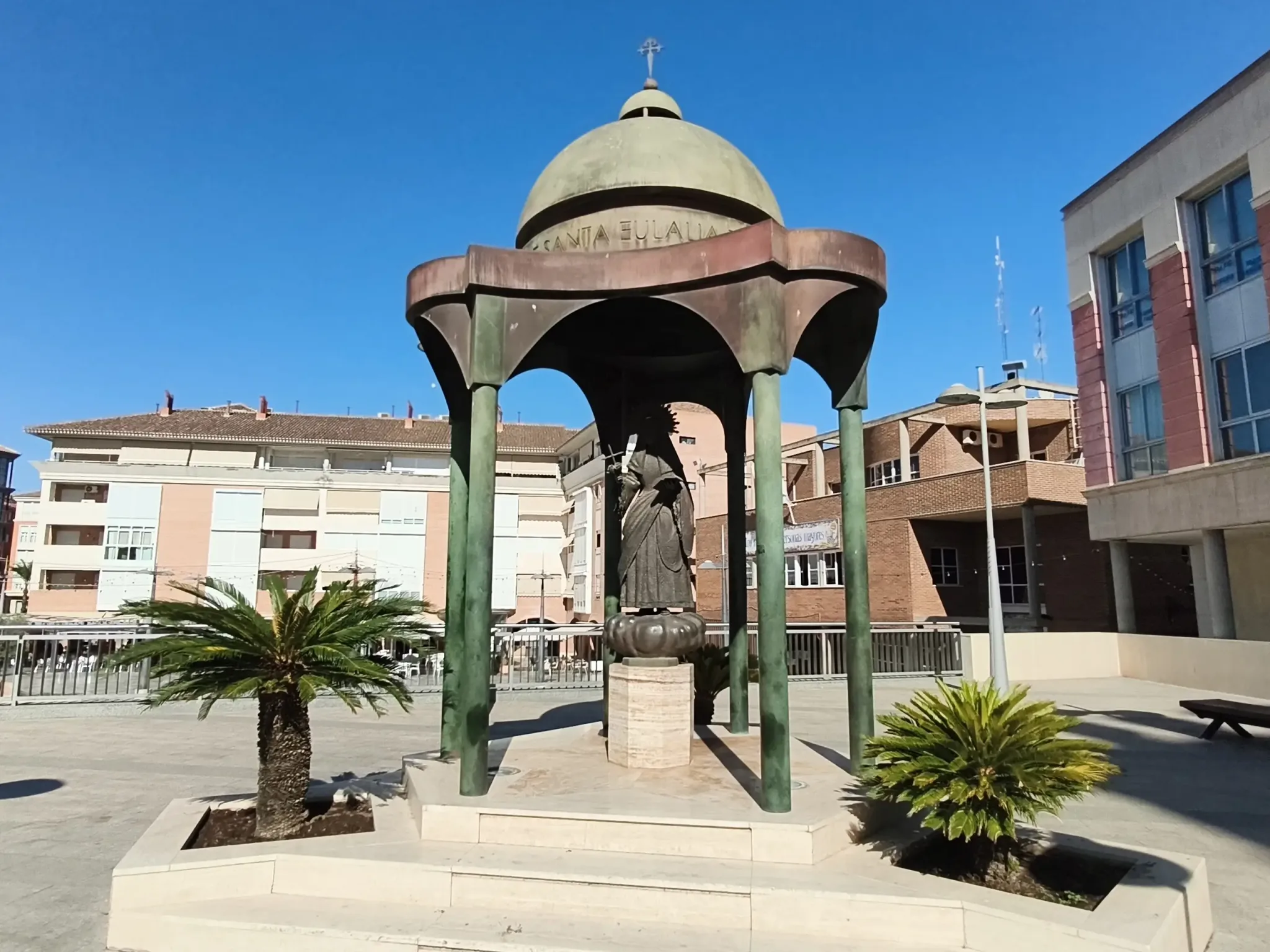 Statue sous un auvent en forme de dôme dans une place paysagée de Totana